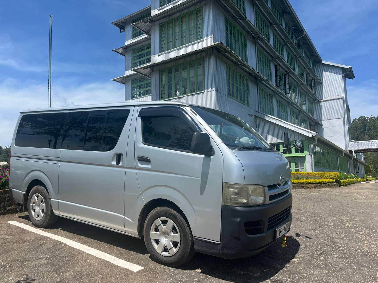Buwi Tours driver talking with a family of tourists by their SUV near Sigiriya, Sri Lanka